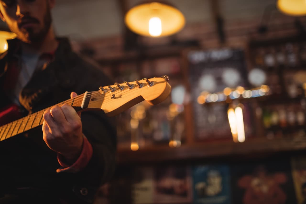 Guitar headstock with bar in background